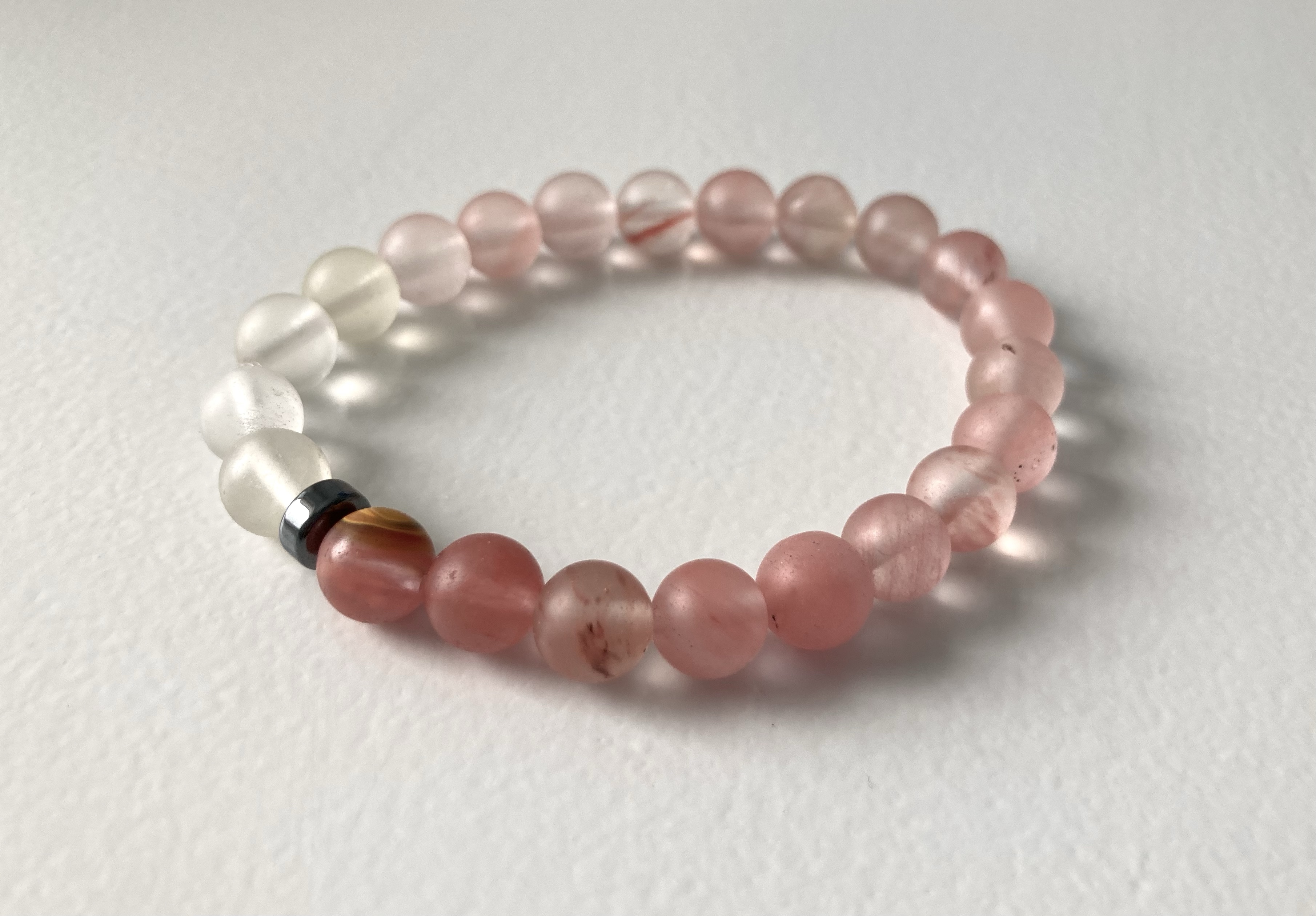 Bracelet from recycled glass beads in pink, white and transparent shades, and a black tourmaline to hide the knot. (Copyright Maria Liv)